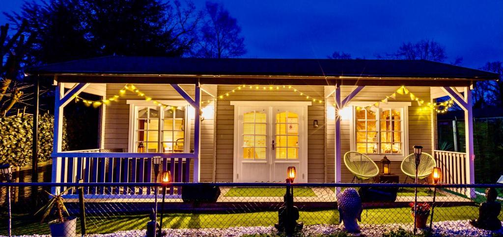 a small house with lights on the front of it at The Retreat Log Cabin in Sudbury