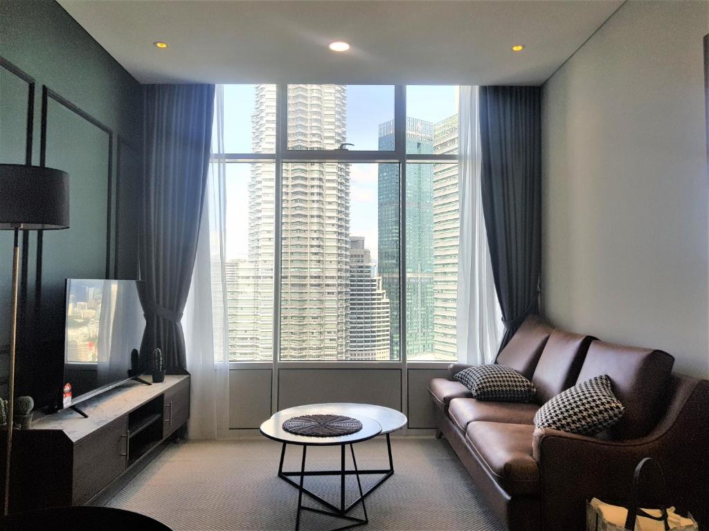 a living room with a couch and a large window at Sky Suites KLCC by Asiapex in Kuala Lumpur