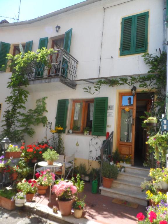 una casa con persianas verdes y flores delante de ella en Soluna en Maresca