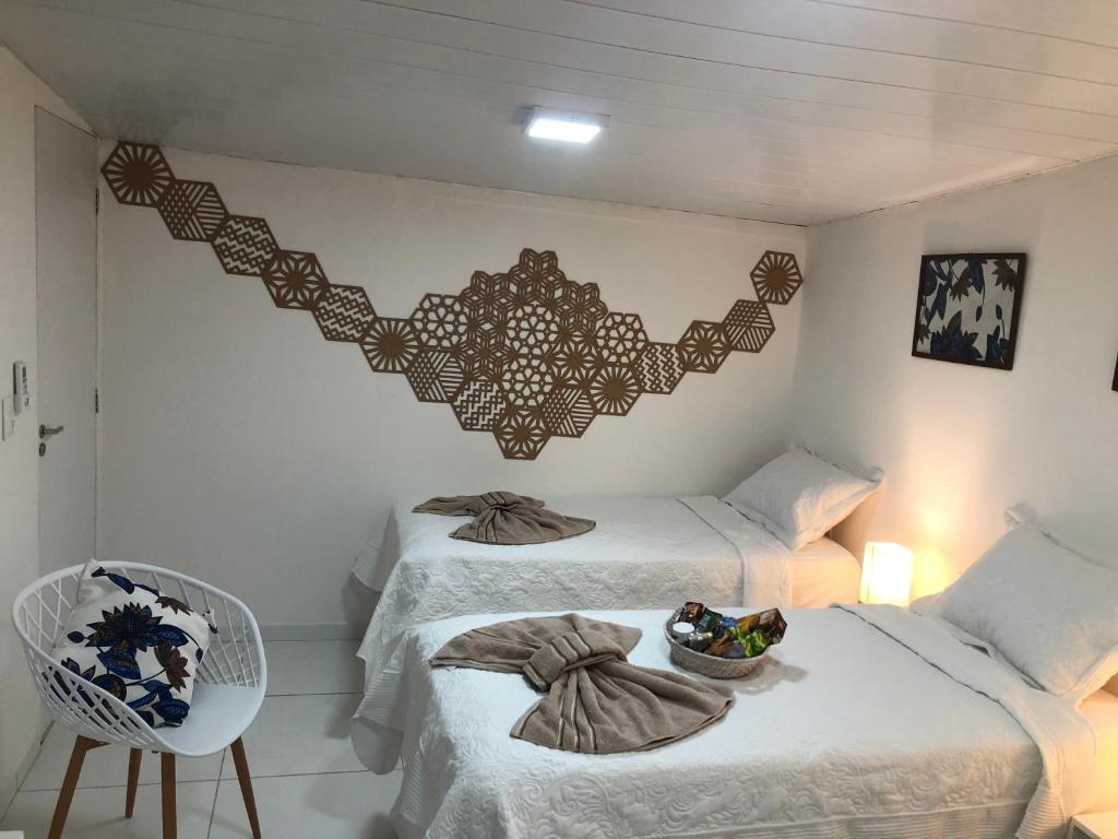 - une chambre avec 2 lits et une corbeille de fruits sur le lit dans l'établissement Toca da Villa, à Fernando de Noronha