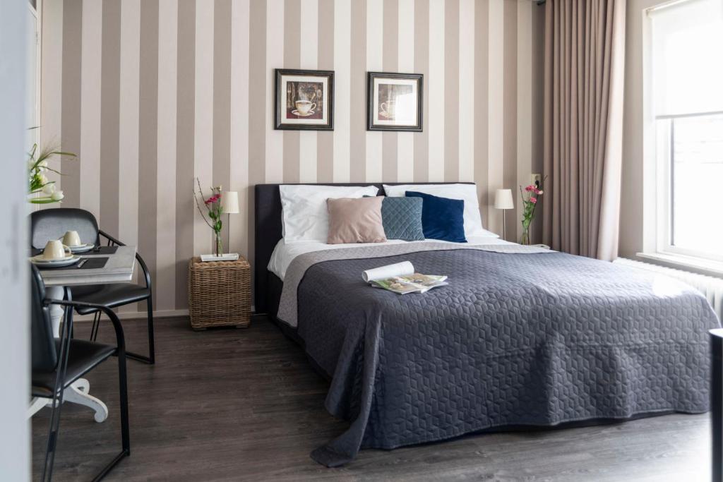 Un dormitorio con una cama, una mesa y una silla. en Suite 16, en Axel