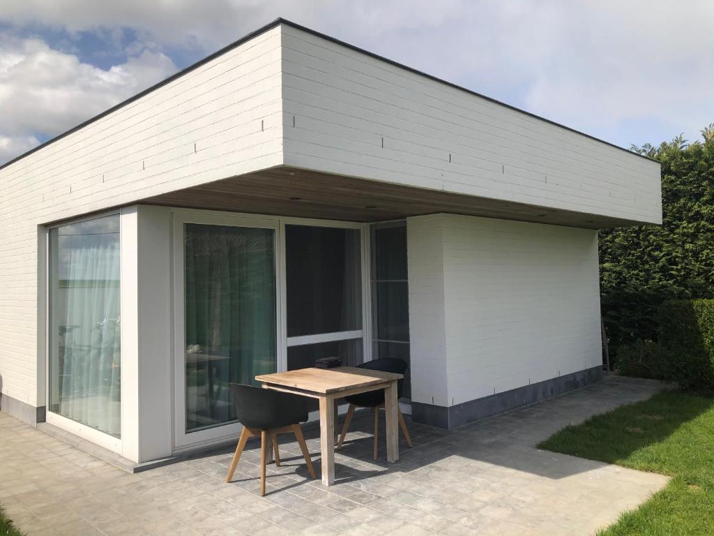 a pavilion with a table and chairs on a patio at Vakantiehuis Onverbloemd in Tielt