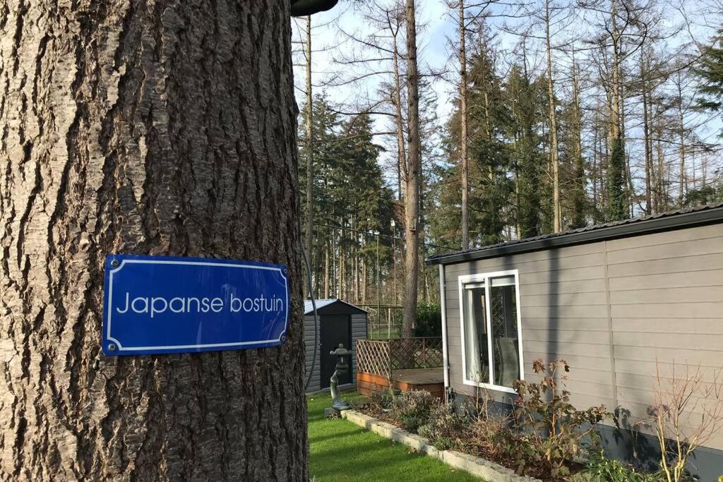 ein blaues Schild auf einem Baum neben einem Haus in der Unterkunft Japanse bostuin met Wifi in Lochem