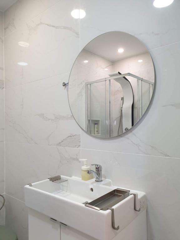 uma casa de banho branca com um lavatório e um espelho em AAA Ana Albufeira Apartments em Albufeira