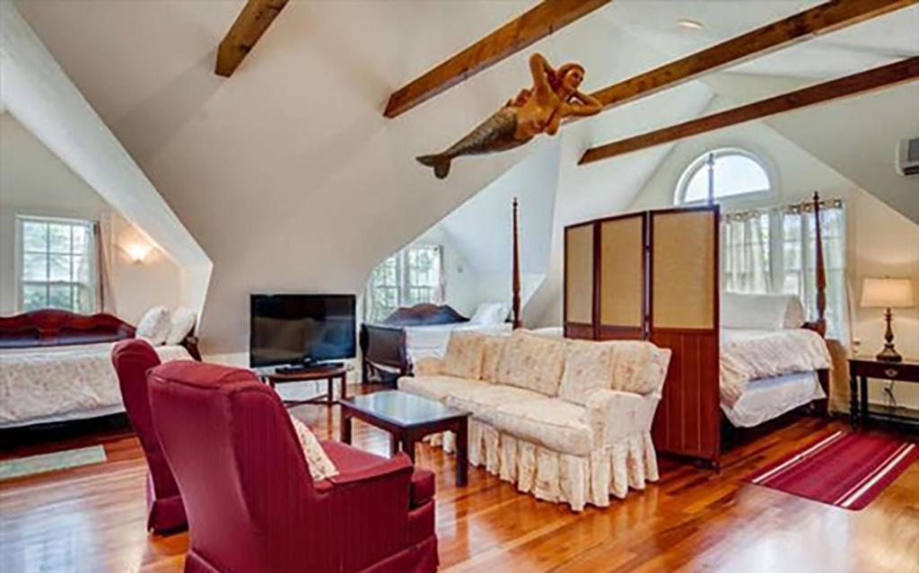 a living room with a couch and a bed at West Tisbury Inn in West Tisbury