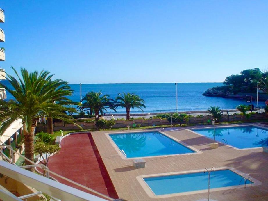 ein Resort mit zwei Pools und dem Meer im Hintergrund in der Unterkunft Voramar in Calpe