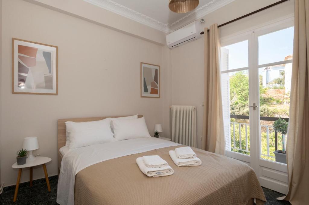 1 dormitorio blanco con 1 cama con 2 toallas en Navarino Apartment en Pylos