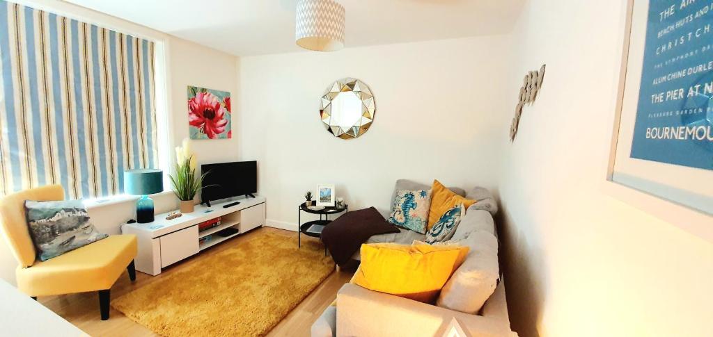 uma sala de estar com um sofá e uma televisão em Stunning apartment with 2 bedrooms, 2 en-suites, private parking em Bournemouth