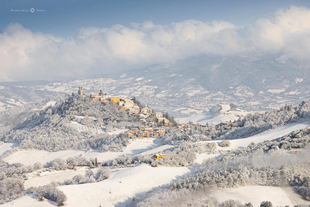una casa in cima a una montagna nella neve di La vedetta del Montefeltro a Peglio
