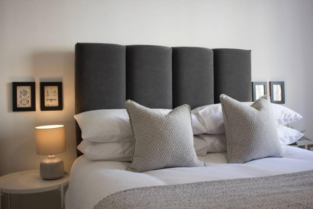 um quarto com uma cama grande e almofadas brancas em Apartments in the heart of Penzance em Penzance