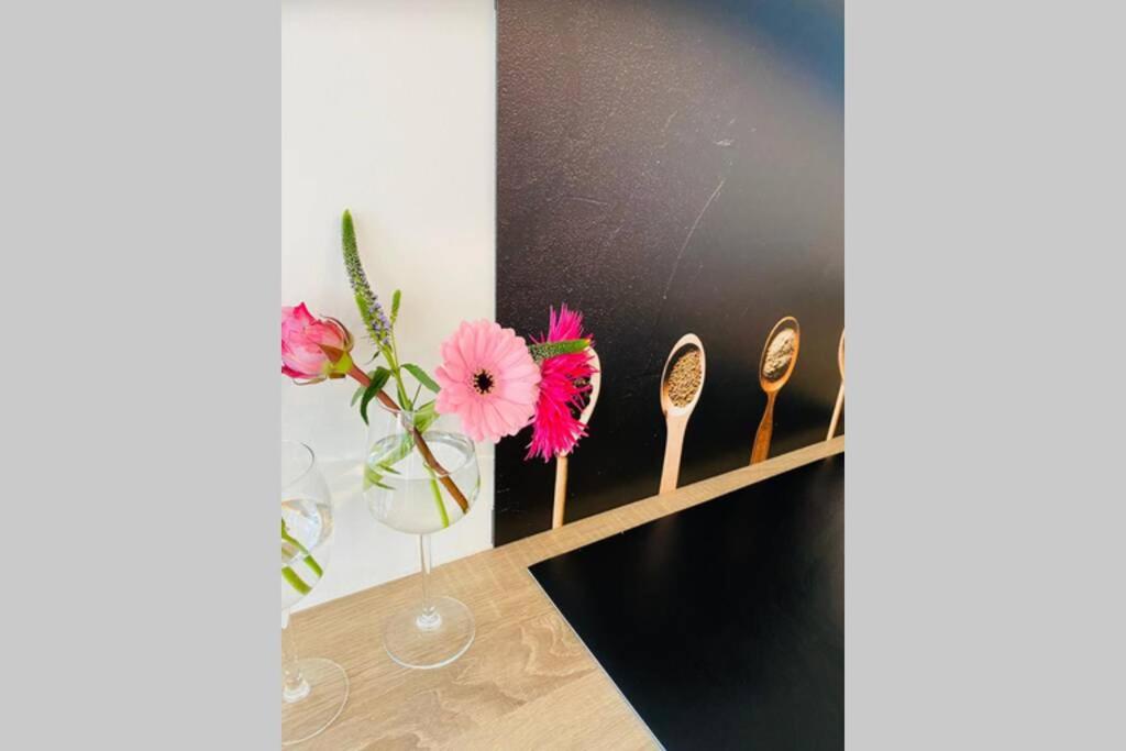 una habitación con una mesa con flores en un jarrón en Warm welkom! Zeer ruime privé studio met tuin en Harlingen