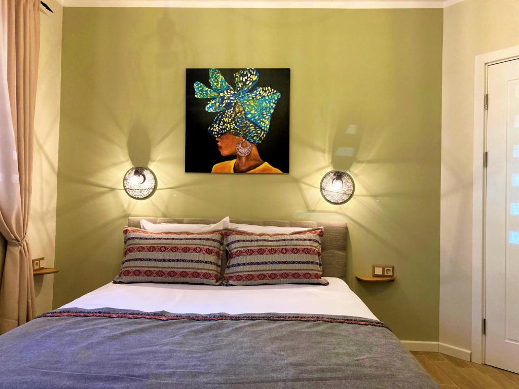 Schlafzimmer mit einem Bett mit Wandgemälde in der Unterkunft Diva Garden Apartment in Plowdiw