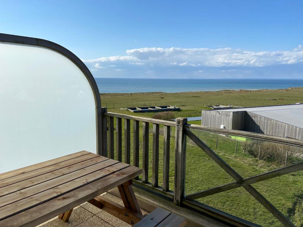 une terrasse avec un banc et une vue sur l'océan dans l'établissement La mer vue d'en haut , duplex à la naturelle sur la côte d'opale, à Wimereux