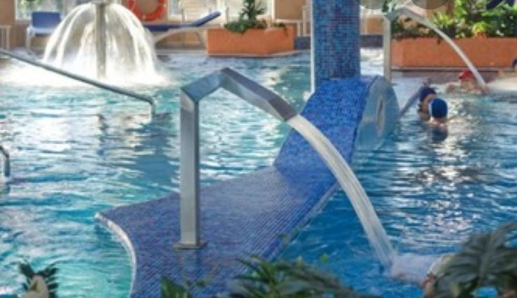 basen z fontannami wodnymi i ludźmi w nim w obiekcie Atico Cuntis Thermae w mieście Cuntis