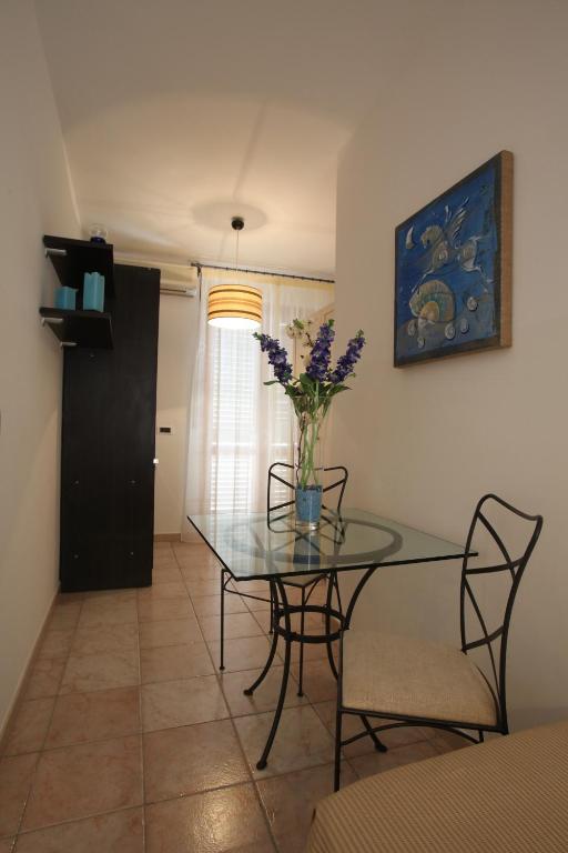 a dining room table with a vase of flowers on it at La Casa dei Venti - Aeolian Charme in Canneto