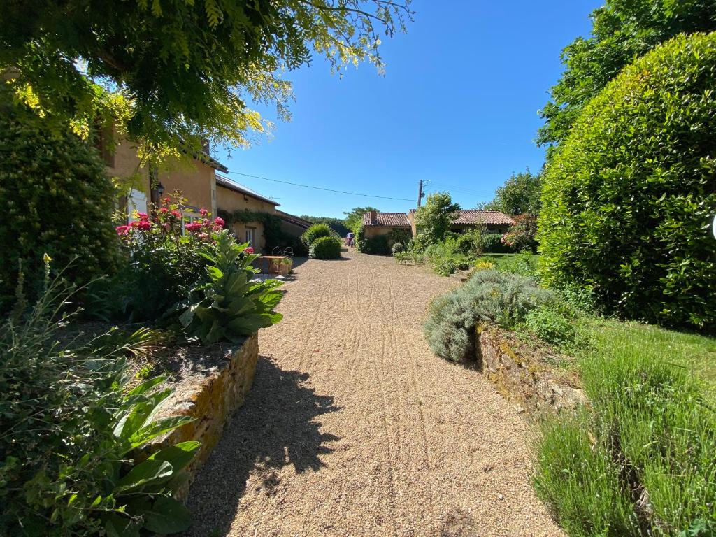 a path in a garden with flowers and plants at La Fermette Aux Canards in Savigny-Lévescault