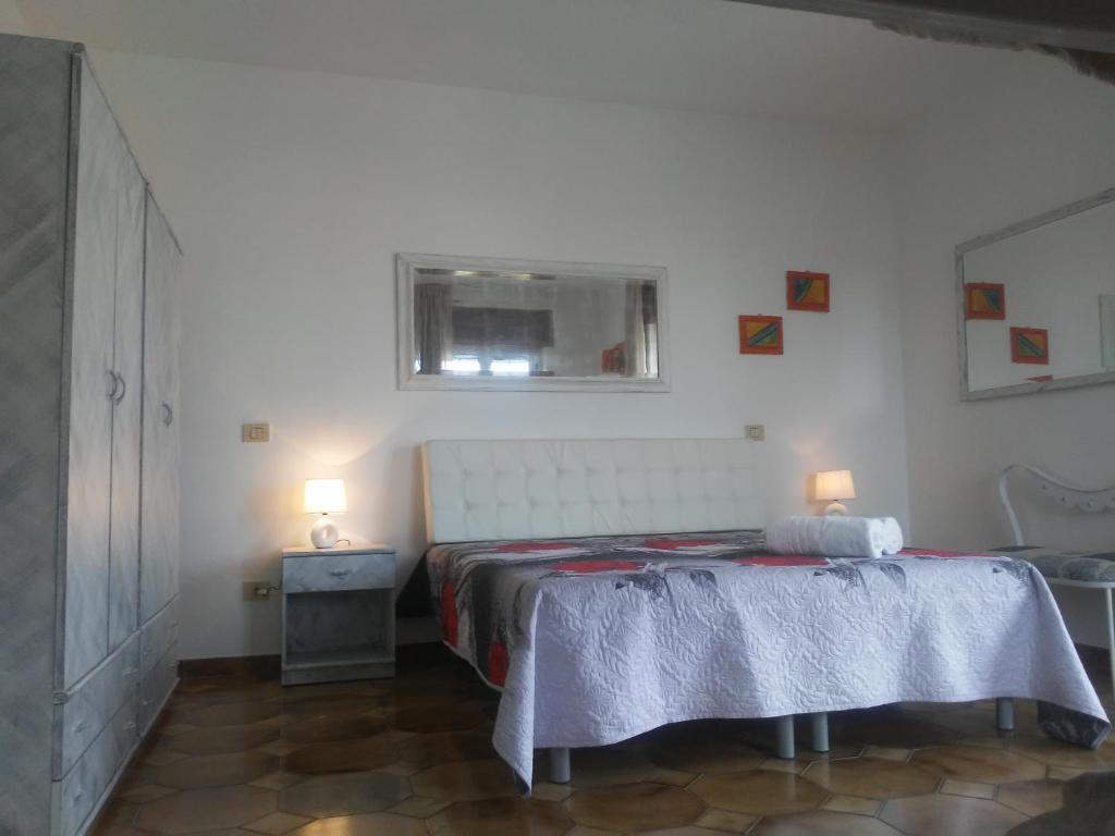 een slaapkamer met een bed, een raam en 2 lampen bij Villa Rita in Peschici