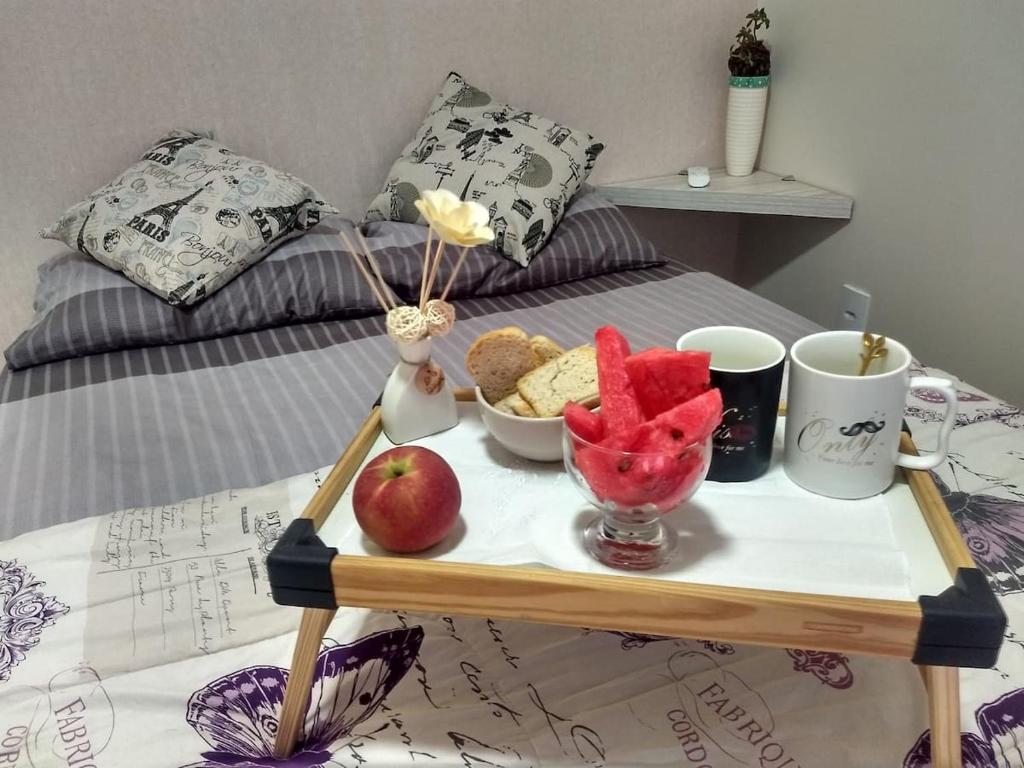 a tray of food on a table on a bed at Cantinho da Florzinha in Foz do Iguaçu