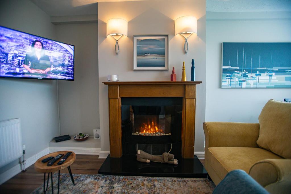 a living room with a fireplace and a tv at Garavogue Villa in Sligo