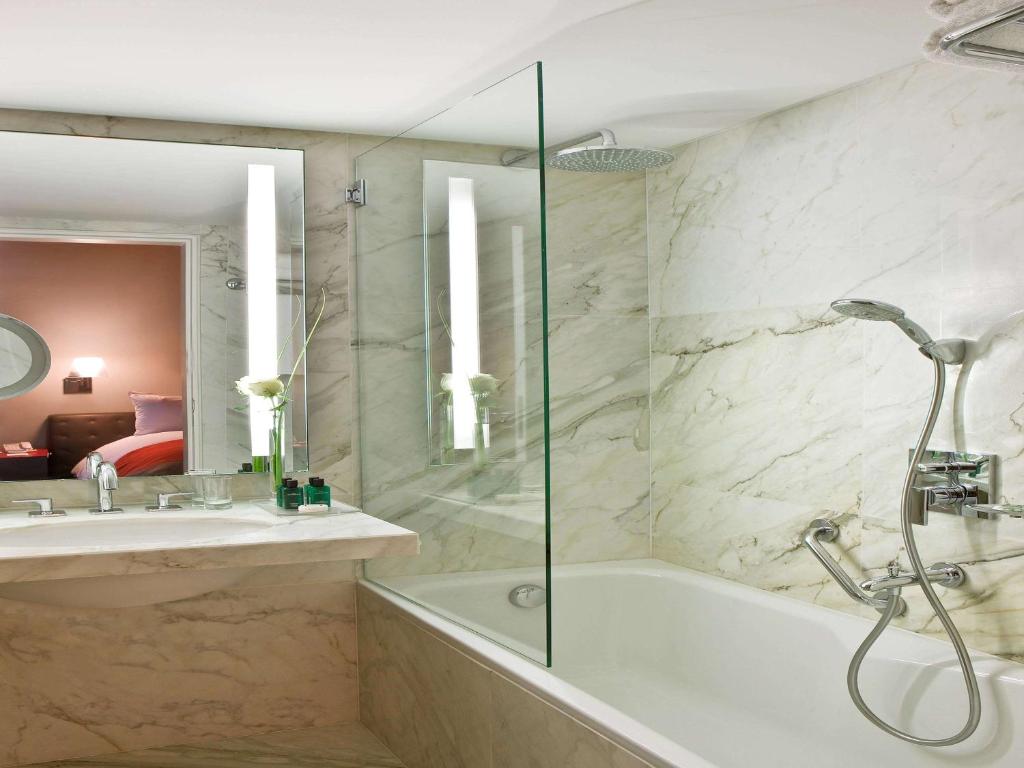 une salle de bain avec une baignoire, un lavabo et une douche dans l'établissement Sofitel Abidjan Hotel Ivoire, à Abidjan