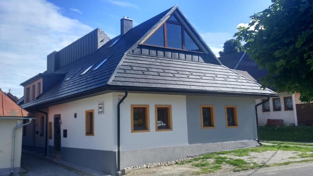 a small white house with a gambrel roof at Privat LeNa in Ružomberok