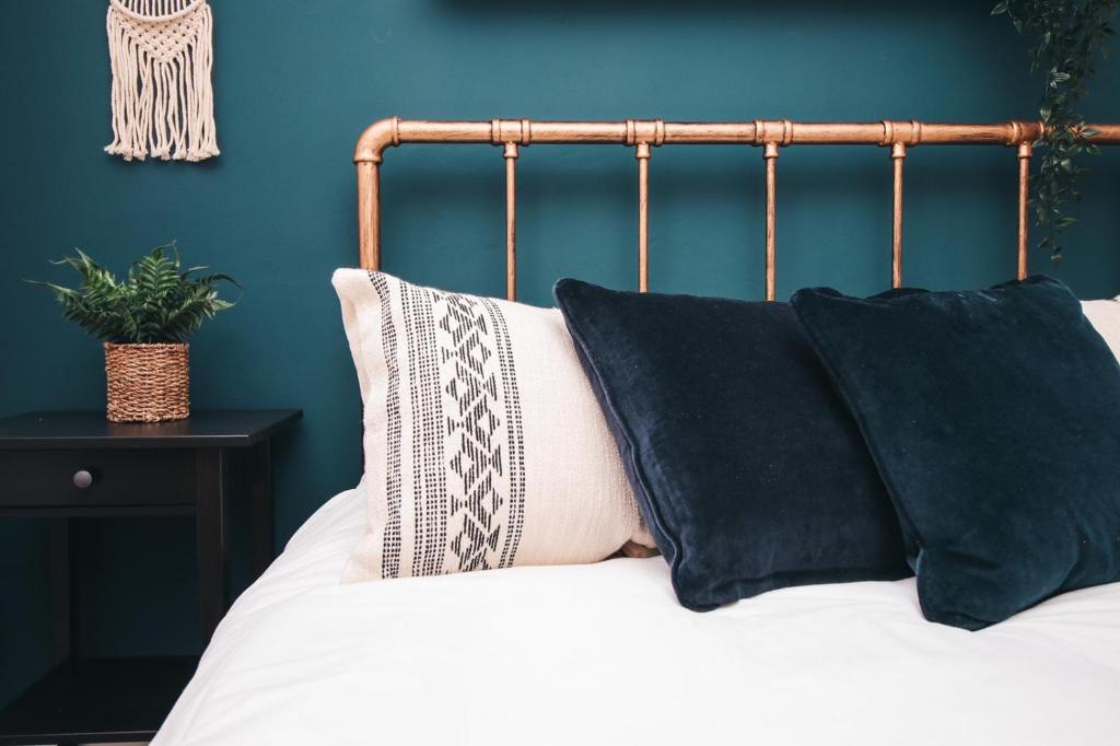 a bed with black and white pillows on it at Commercial House, By Solace Stays in Newport