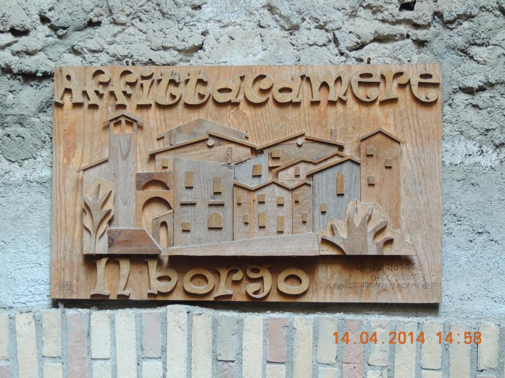 una señal de madera en un lateral de una pared en Il Borgo Affitacamere, en Castiglione in Teverina