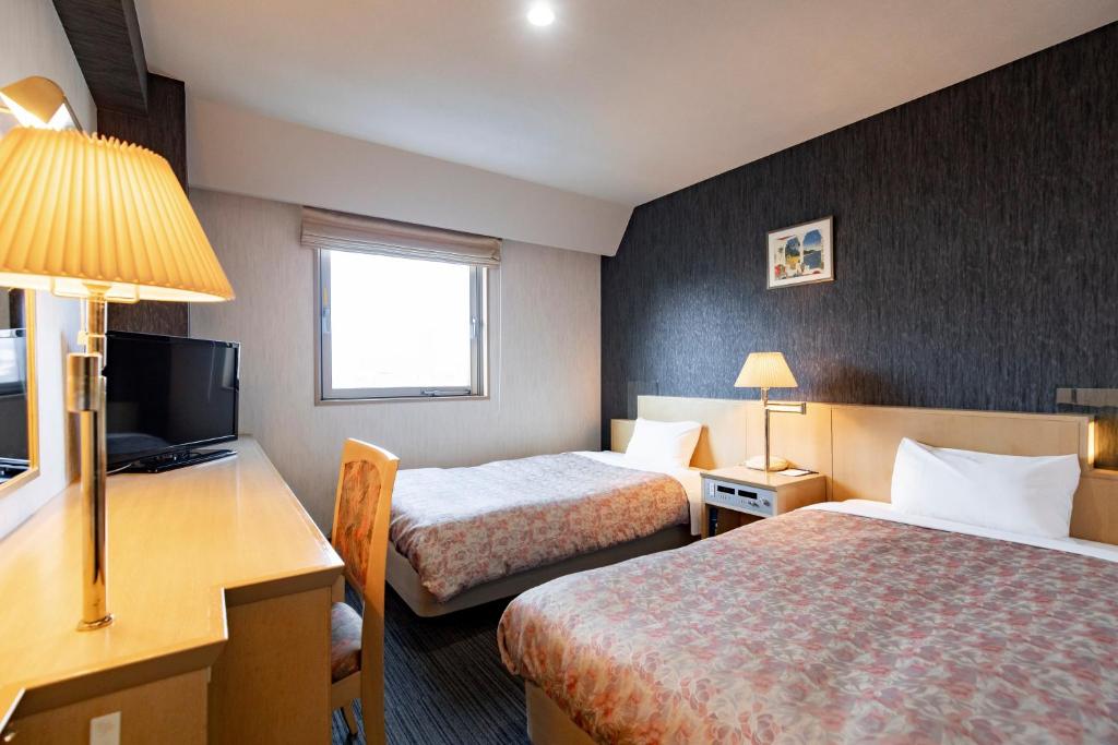 Postel nebo postele na pokoji v ubytování Kanazawa Central Hotel Annex