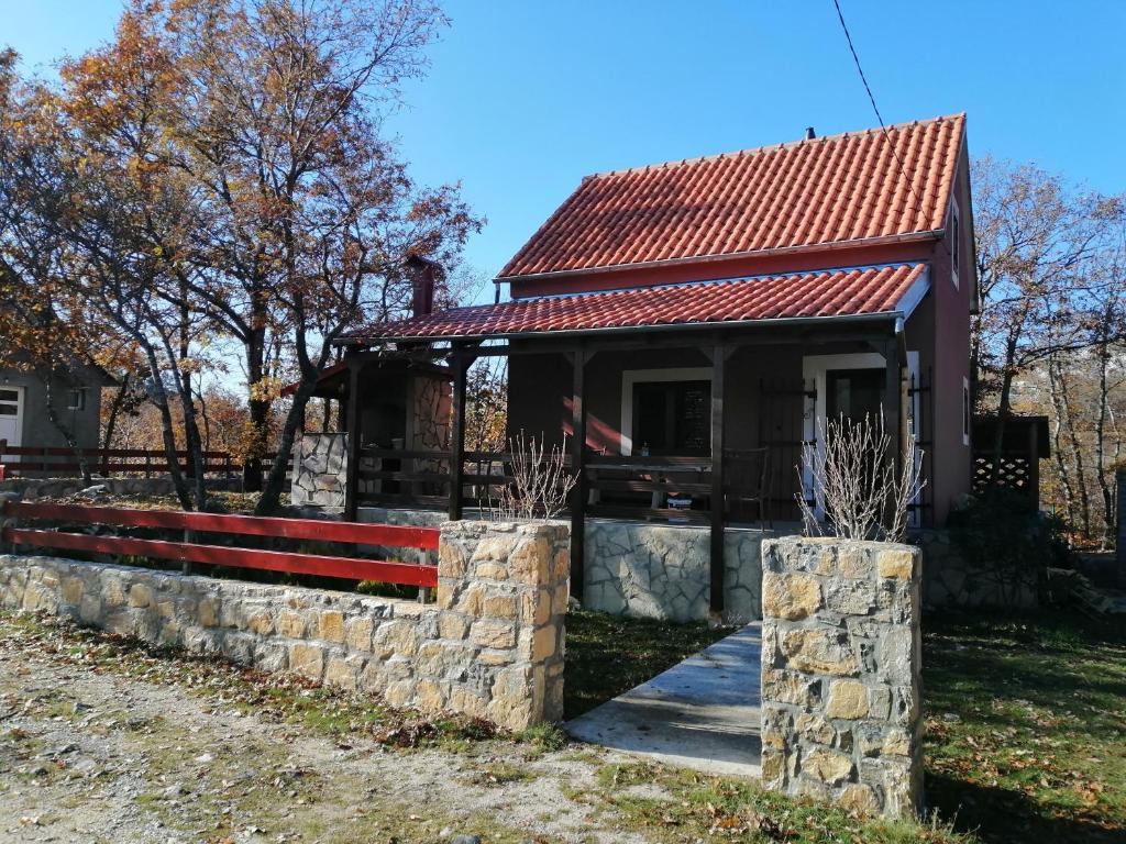 a small house with a stone wall and a roof at Holiday Home Nikolić in Njeguši