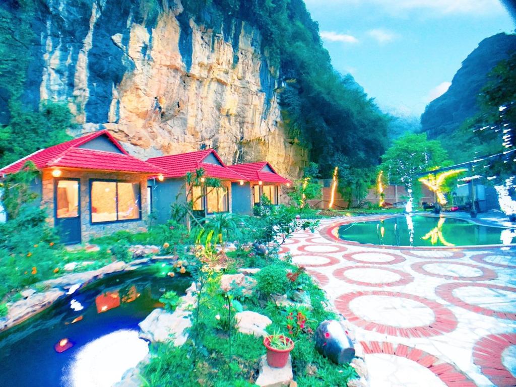 寧平的住宿－Trang An Peaceful Homestay，一座带池塘的房子和一座建筑的画