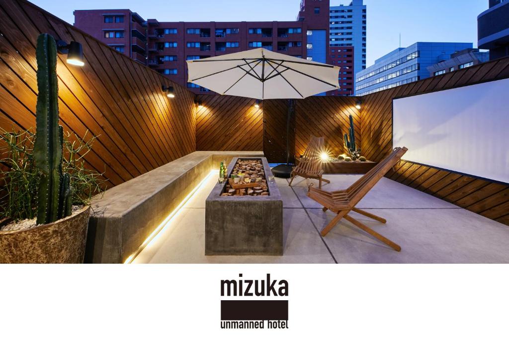 un patio con mesa y sombrilla en mizuka Daimyo 7 - unmanned hotel -, en Fukuoka