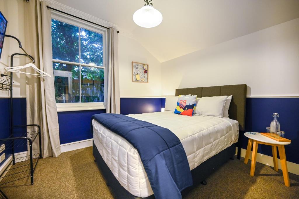 a bedroom with a bed with blue walls and a window at U Boutique on Haven in Nelson