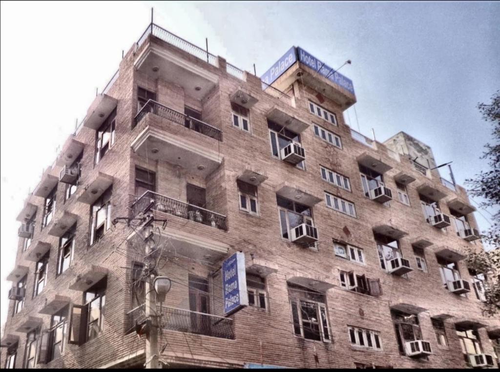 un gran edificio de ladrillo con ventanas y balcones en Vamoose Rama Palace en Gangānagar