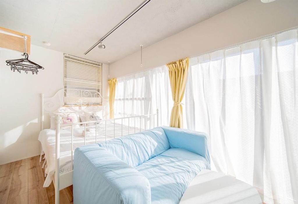 une chambre avec un lit et un canapé bleu dans l'établissement japan house ebisu, à Tokyo