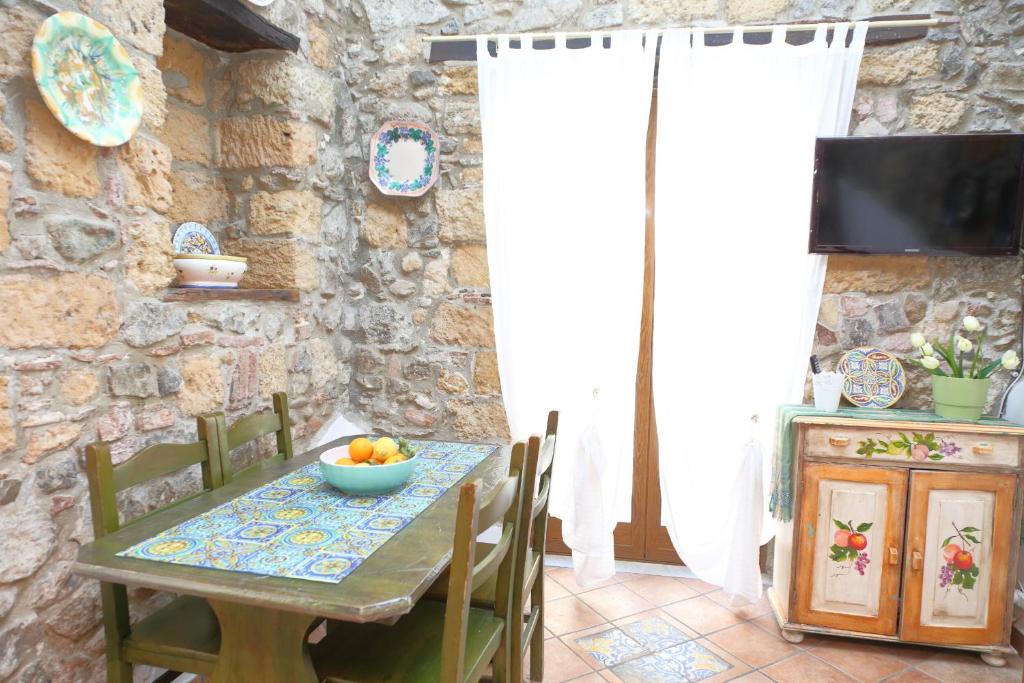 a dining room with a table with a bowl of fruit on it at Casa Saraceni (by Vacation Service) in Cefalù