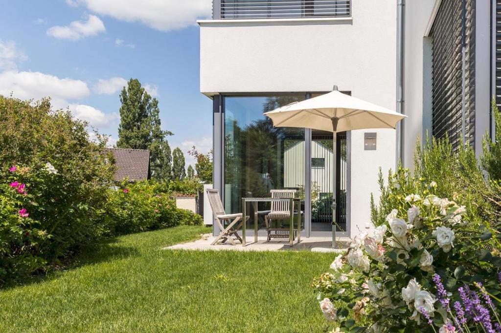 un jardín con mesa y sombrilla en Mettnau-apartment, en Radolfzell am Bodensee