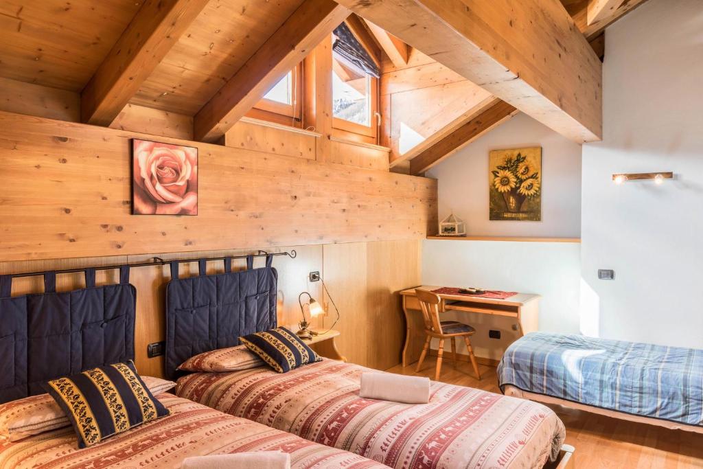 twee bedden in een kamer met een houten plafond bij Nadir - Casa Azzurra in Livigno