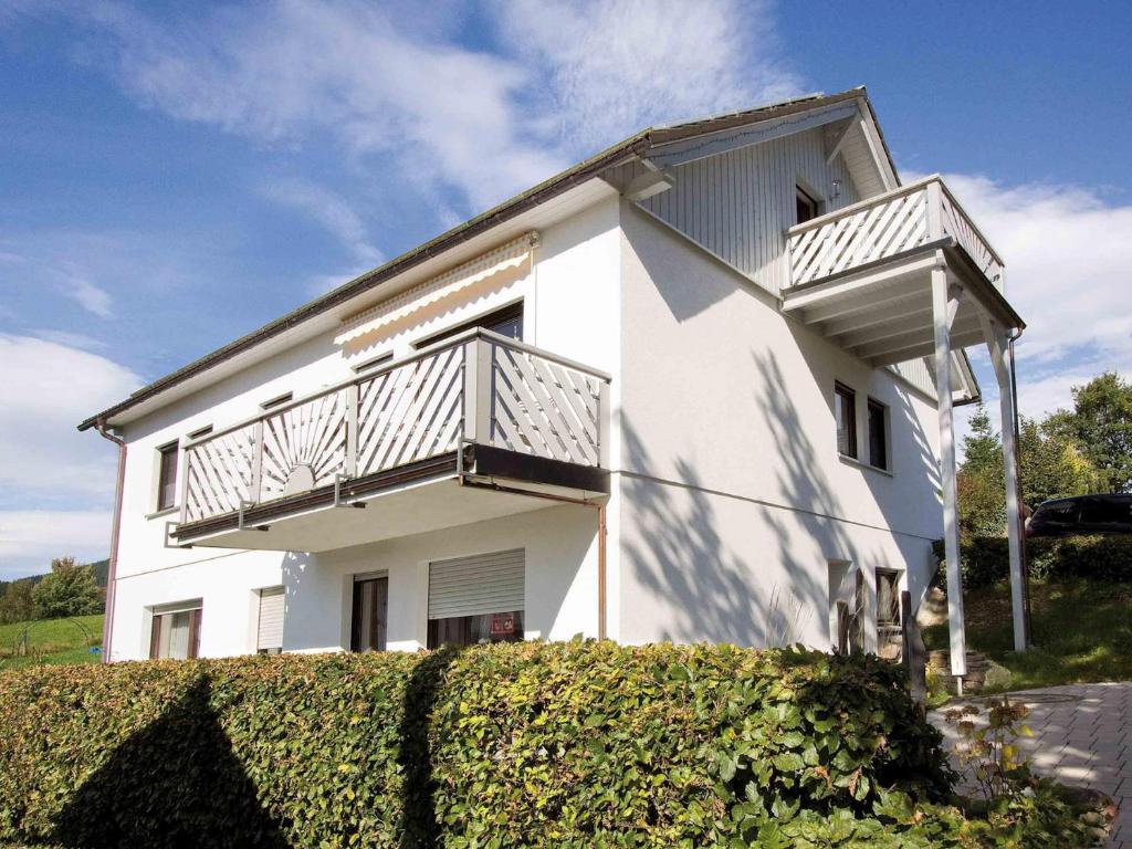 Cette maison blanche dispose d'un balcon sur le côté. dans l'établissement Haus Wanderglück, à Schmallenberg