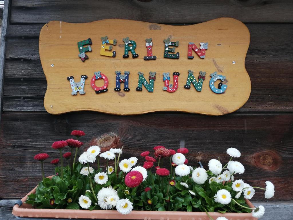 a wooden sign that says new dwelling with flowers at Ferienwohnung mit Charme und Blick auf Dinkelsbühl in Dinkelsbühl