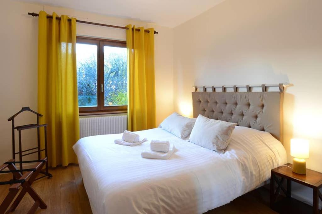 ユナヴィールにあるLe Verger - Maison de vacances Route des Vinsのベッドルーム(黄色のカーテン付きの大きな白いベッド1台付)