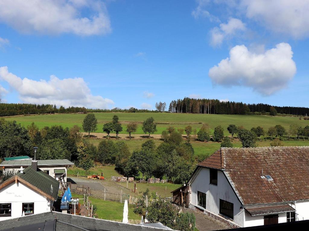 Blick auf einen Bauernhof mit einem Feld und Bäumen in der Unterkunft Cafe-Restaurant Vedder in Herscheid
