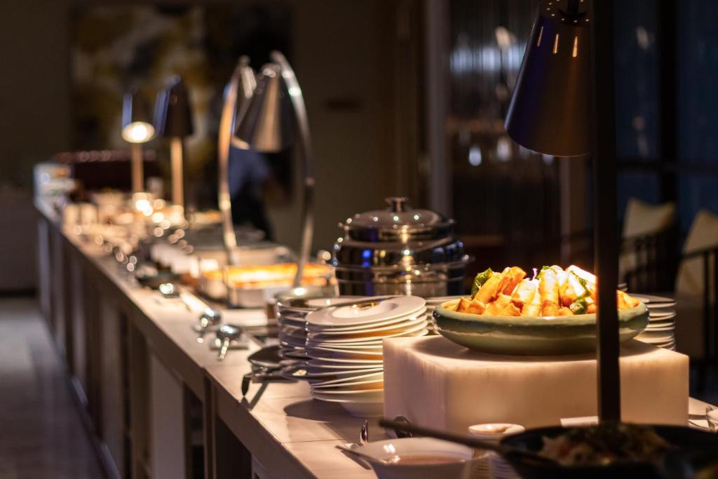 a buffet line with plates and a bowl of food at InterContinental Phuket Resort by IHG in Kamala Beach
