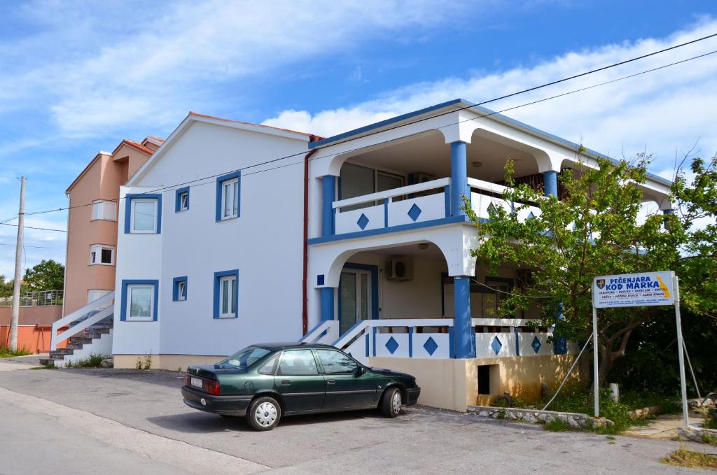 zielony samochód zaparkowany przed domem w obiekcie Pool Apartments Knežević Novalja w Novalji