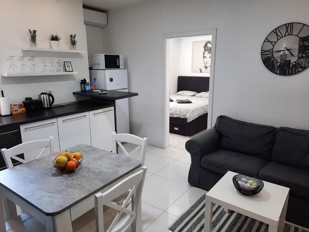 een keuken en een woonkamer met een tafel en een bank bij Zagreb Creative Apartments APP 1 in Zagreb