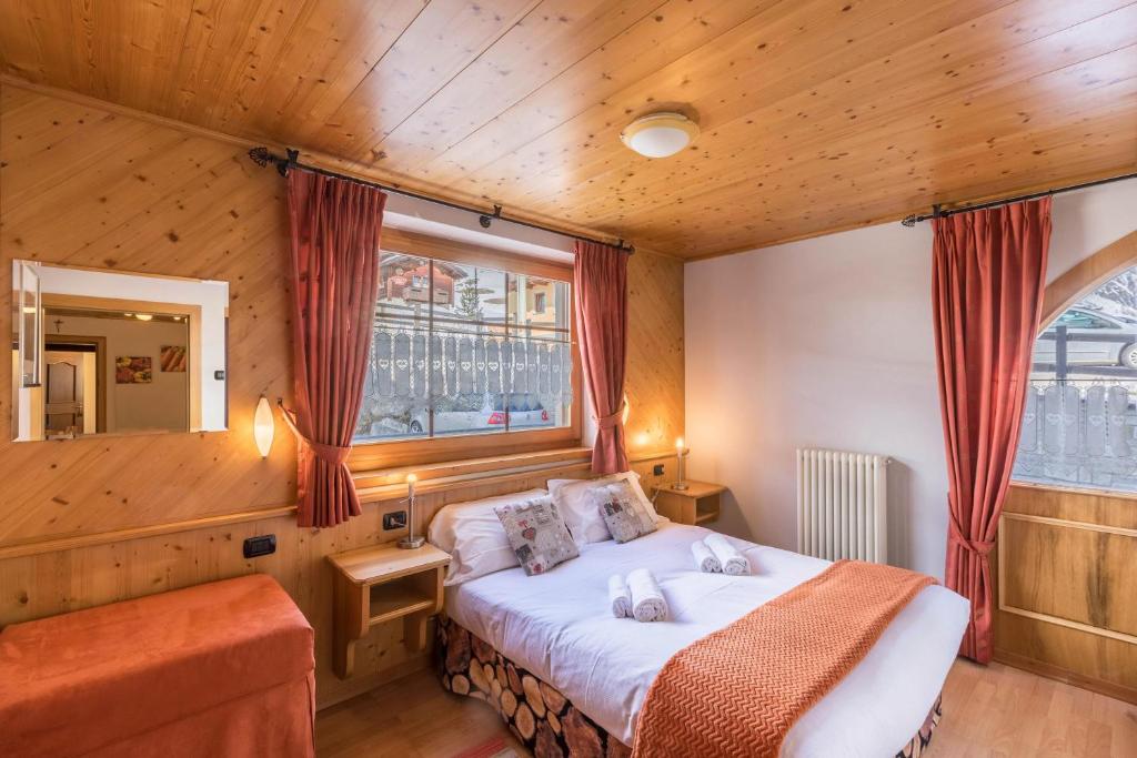 ein Schlafzimmer mit einem Bett und einem Fenster in der Unterkunft Sole - Casa Azzurra Piano Terra in Livigno