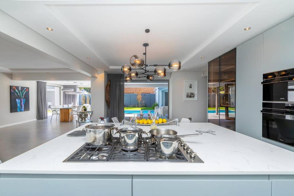 a kitchen with a stove with pots and pans on it at Stunning Villa de Soleil in Cape Town