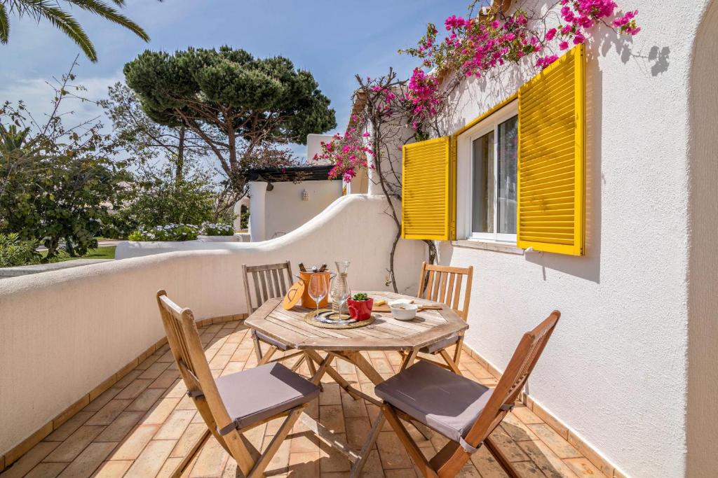 a table and chairs on a balcony with flowers at Casa O12 in Vilamoura