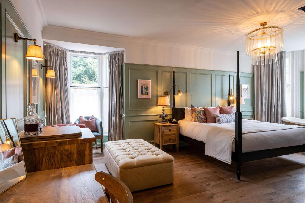 a bedroom with a large bed and a chair at The Canford in Poole