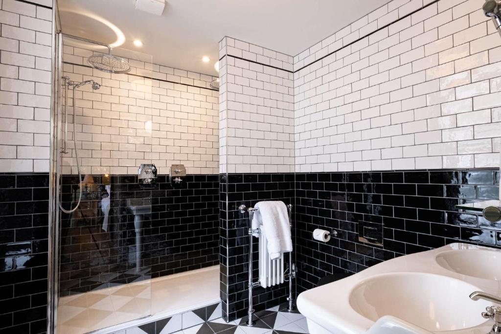 a bathroom with a shower and a sink and a tub at The Canford in Poole