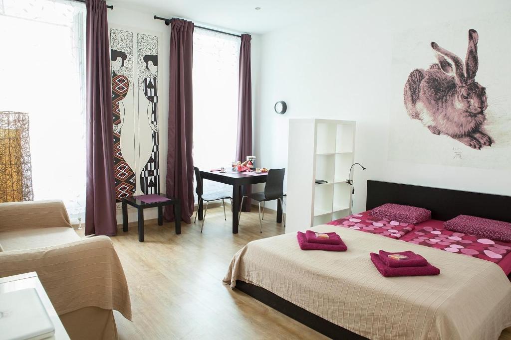 ウィーンにあるMadina Apartmentのベッドルーム1室(ベッド2台、テーブル、デスク付)